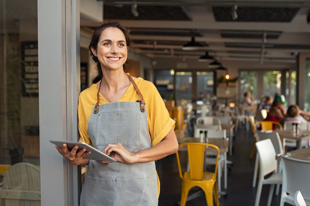 Eine Gastronomin mit ihrer Kasse auf dem Tablet
